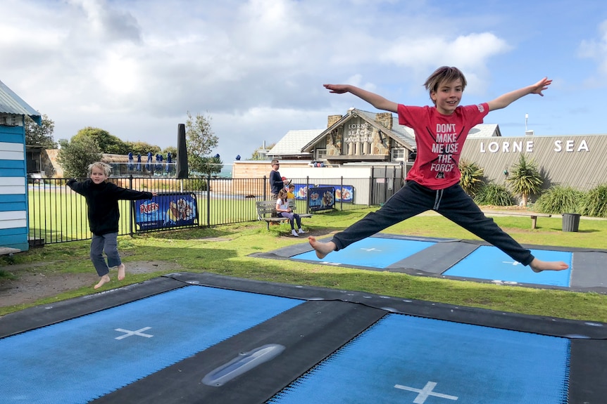 Two boys jumping on the trampolines at Lorne on Victoria's Great Ocean Road