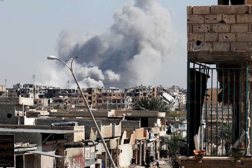 Smoke rises near the stadium where the IS militants are holed up after an air strike.