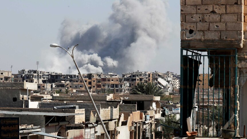 Smoke rises near the stadium where the Islamic State militants are holed up. The site was targeted in an air strike.