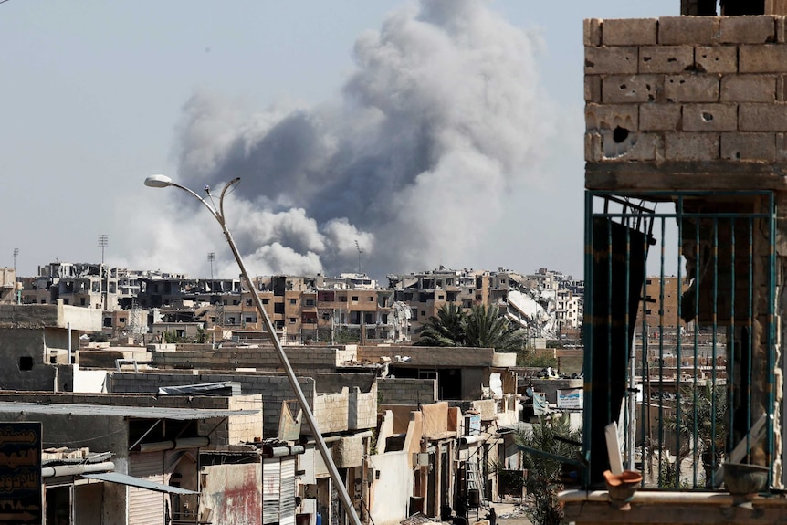 Smoke rises near the stadium where the Islamic State militants are holed up. The site was targeted in an air strike.