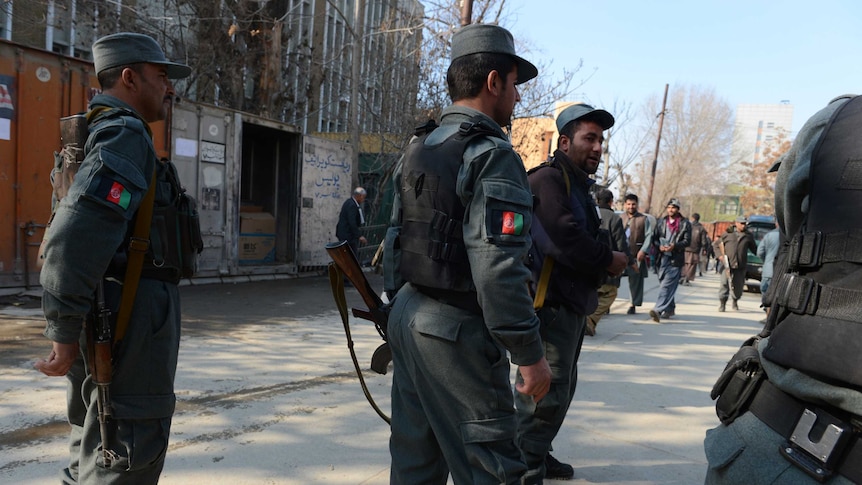 Policemen stand guard after deadly Afghan attack