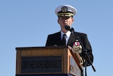 Captain Brett Crozier addressing an audience in uniform.