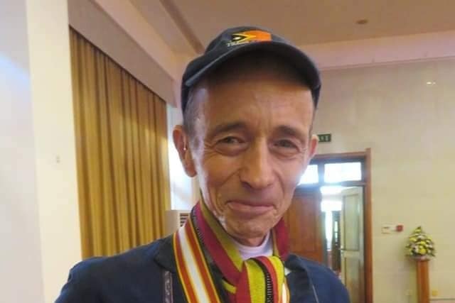 A man wearing a cap wearing a jacket and medals