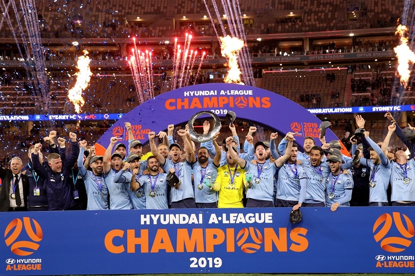 Fireworks shot into the sky while a football team celebrate winning a grand final