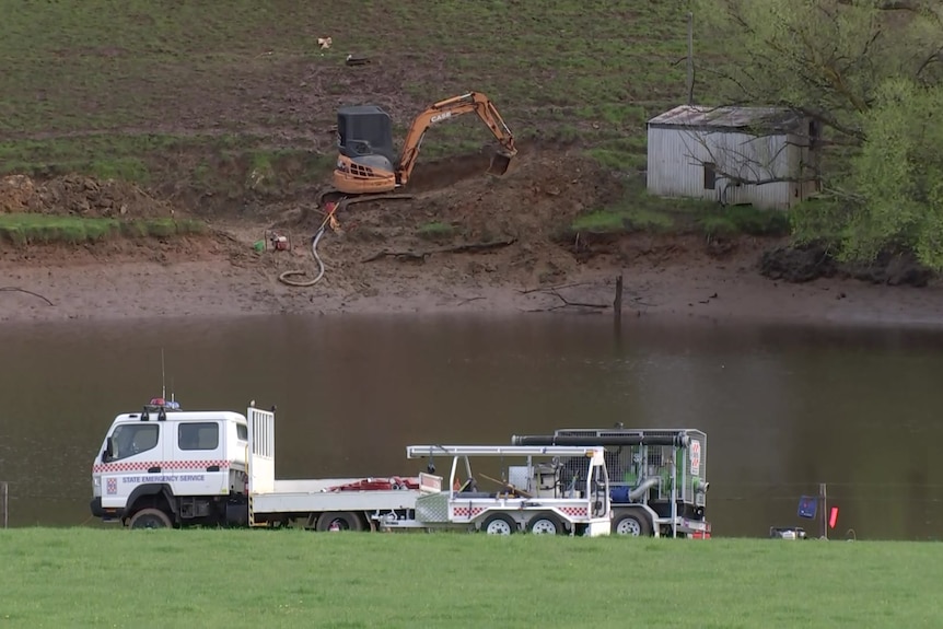 An excavator and a truck at a dam
