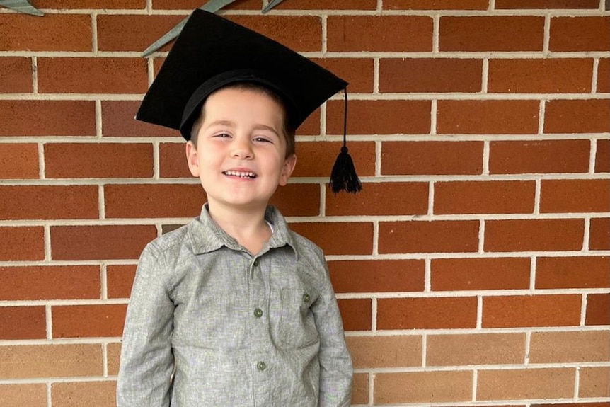 a young boy wearing a graduation cap