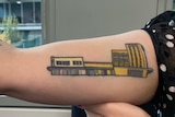 tattoo of three buildings on an arm 