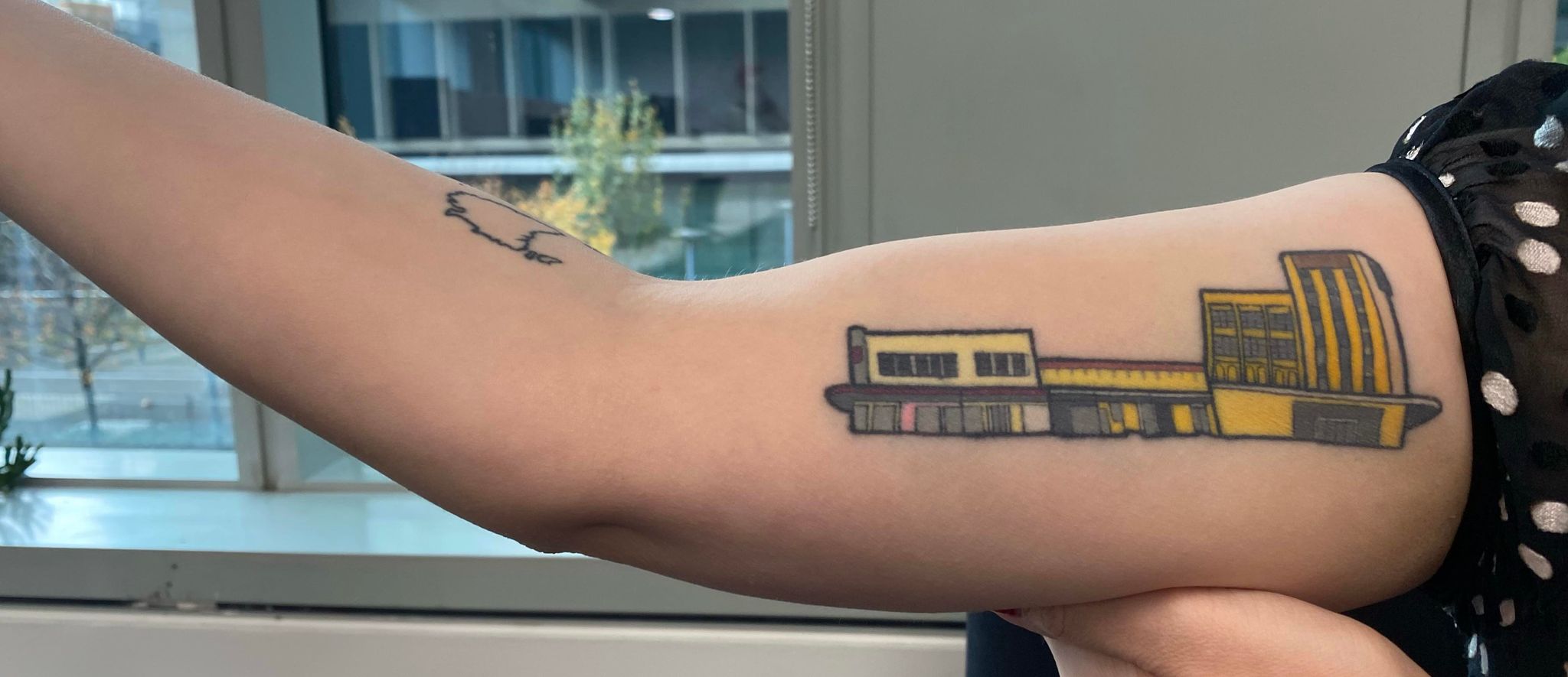 tattoo of three buildings on an arm 