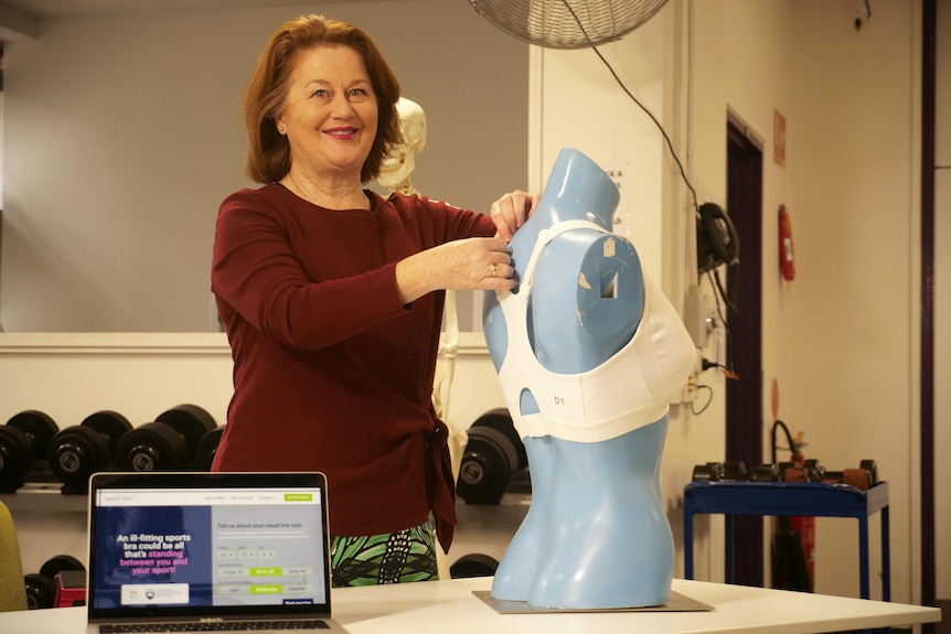 Associate Professor Deidre McGhee fixing a bra on a mannequin. 