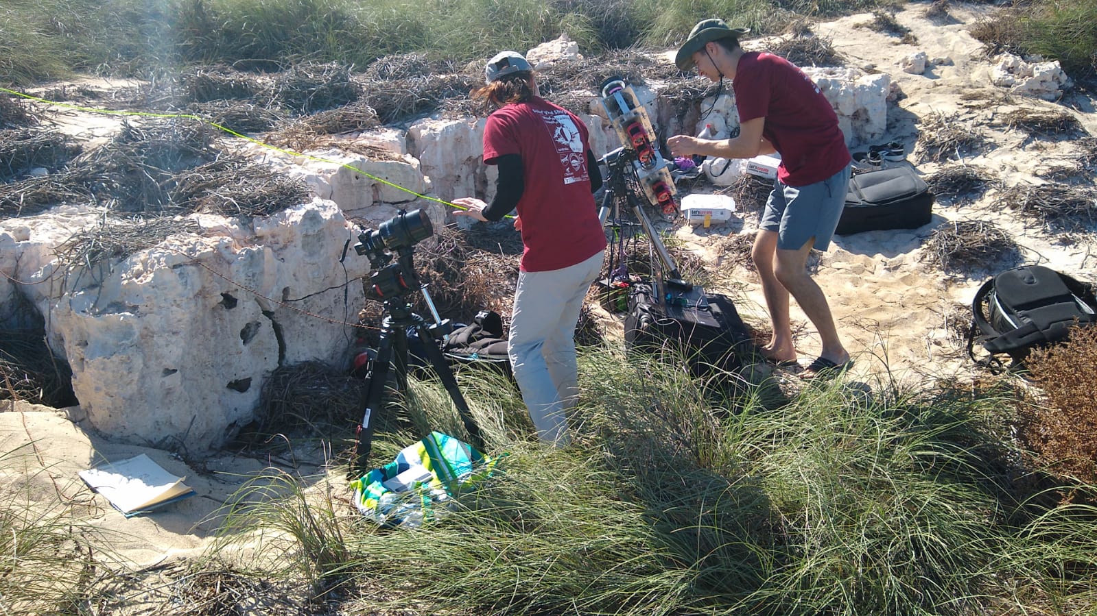 A group of people set up photographic equipment on a remote island.