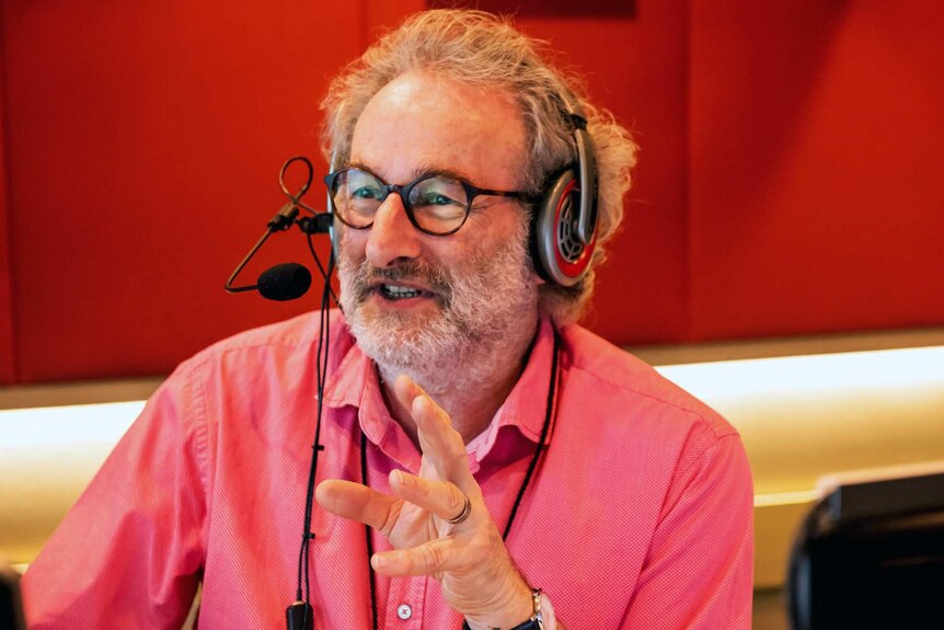 Radio host Jon Faine gestures in studio