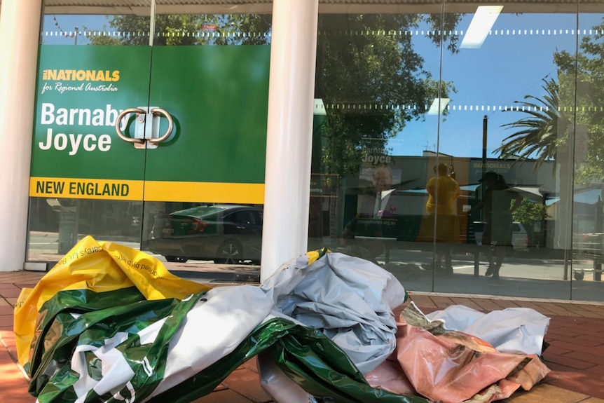 A Barnaby Joyce poster lies crumpled on the ground outside his Tamworth campaign office