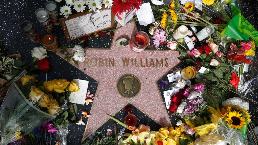 Floral tributes lie around Robin Williams' star on the Hollywood Walk of Fame in Los Angeles on August 12, 2014.