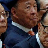 A group of Asian businessman sitting in a row looking serious