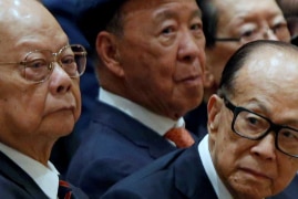 A group of Asian businessman sitting in a row looking serious