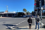 Two people walk in an unusually quiet street of Coffs Harbour