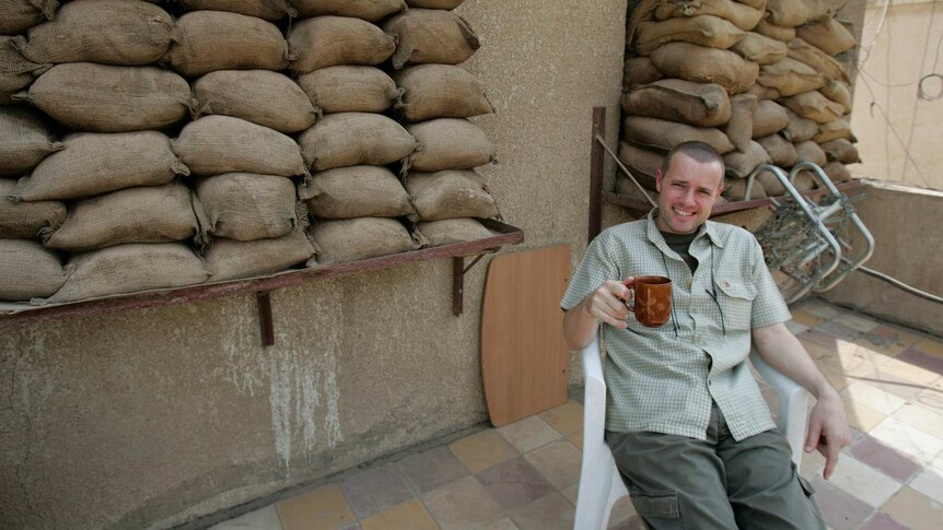 Dean Yates has a cuppa in Baghdad, surrounded by sandbags.
