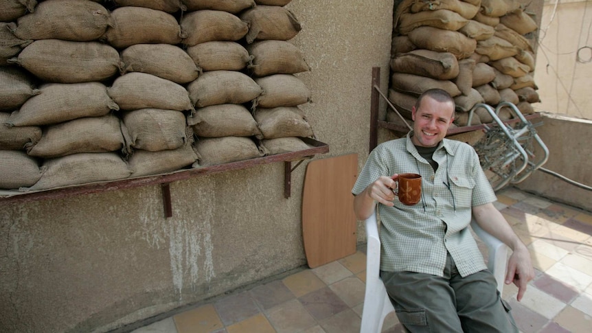 Dean Yates has a cuppa in Baghdad, surrounded by sandbags.