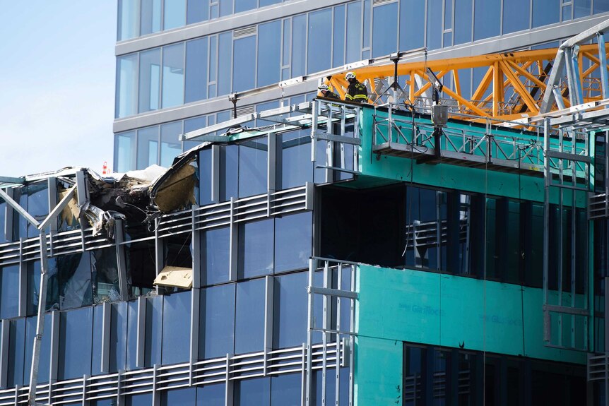 Windows and a roof are smashed on a building in Seattle by crane.