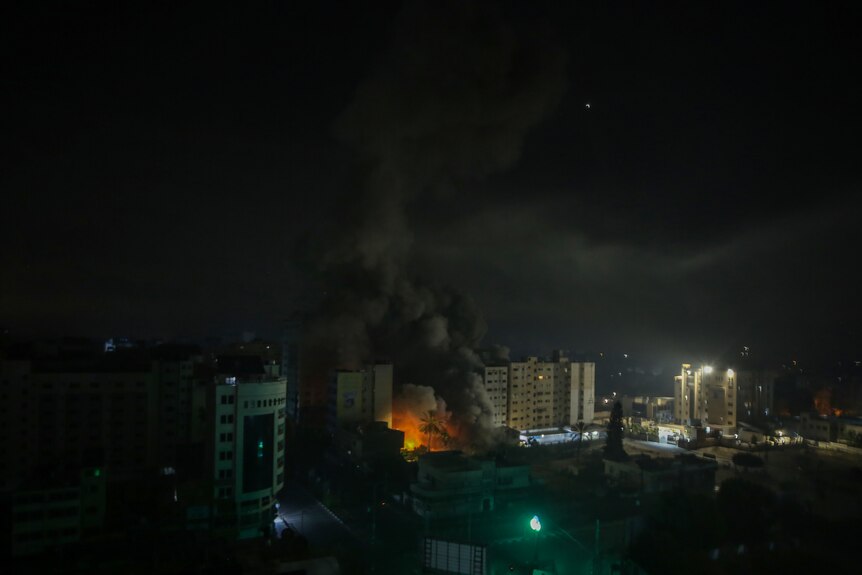 Smoke and flames rise from buildings after bombing.