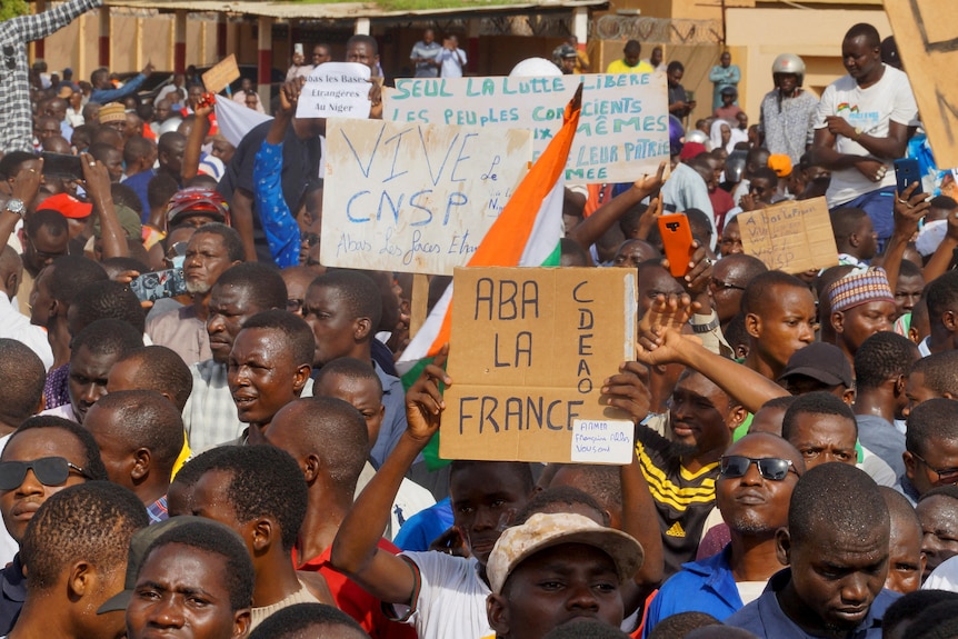 Crowds gather with signs saying Long live CNSP and down with france 