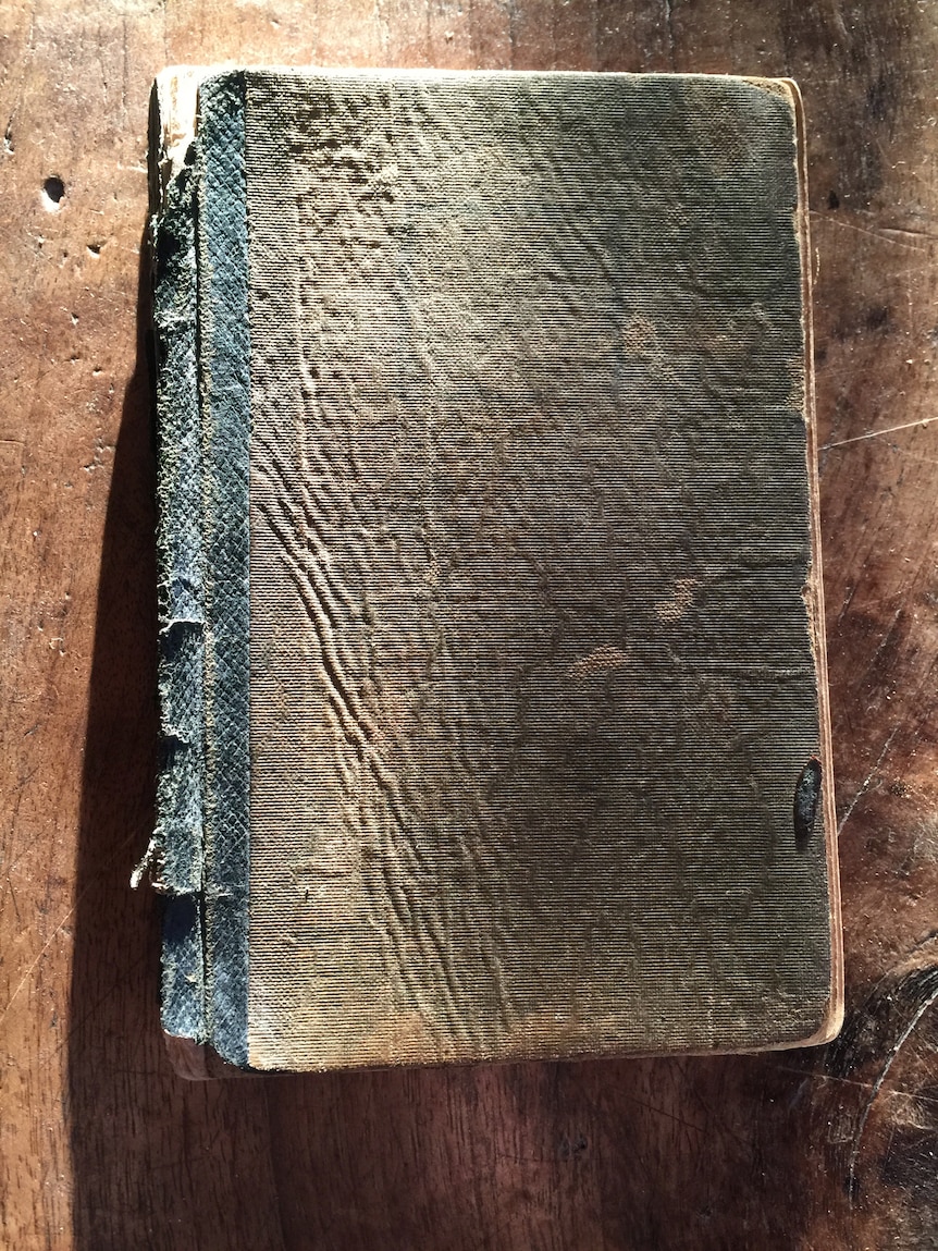 An old diary sitting on a wooden table. 