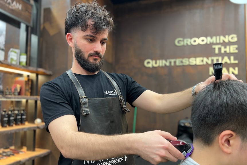 Nimard Zahrah uses a buzzer to cut a customers hair. 