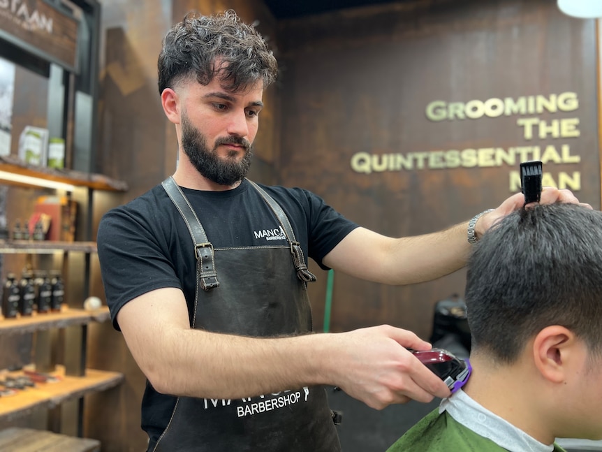 Nimard Zahrah uses a buzzer to cut a customers hair. 