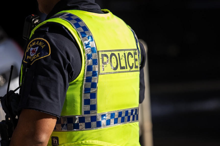 A Tasmanian police officer in a yellow high-vis vest.