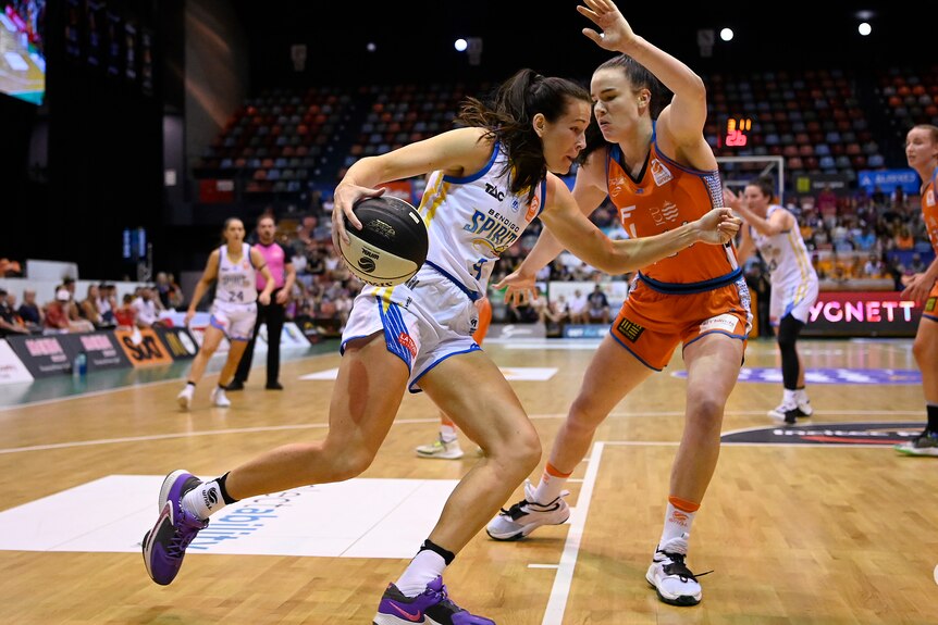 Basketballer Alicia Froling is running, trying to evade a defender