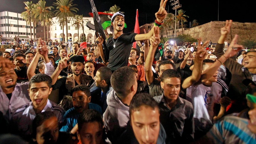 Libyans celebrate in Tripoli's Martyrs Square after hearing of the capture of Moamar Gaddafi's son Mo'tassim.