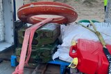 A life buoy, jerry cans and waterproof cases