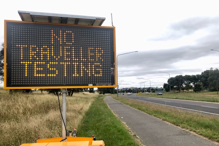 An electronic roadside sign reads 'No traveller testing'