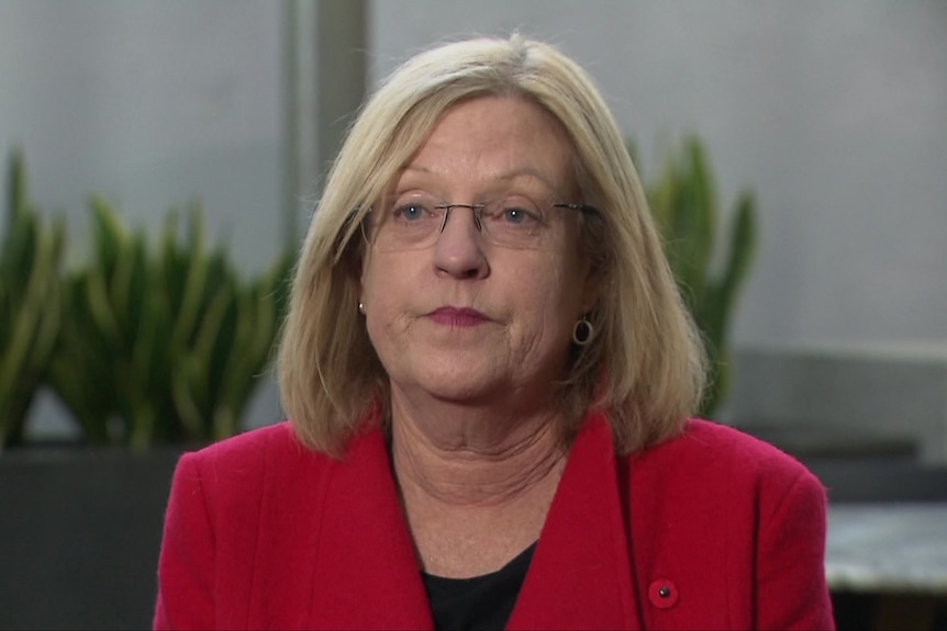 Lisa Neville in a red blazer, looking beyond the camera