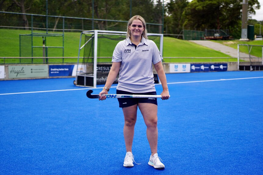 A hockey goalkeeper smiles after training