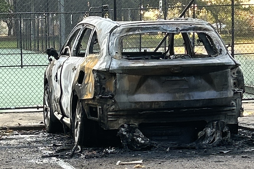 A vehicle in a carpark is burned and blackened