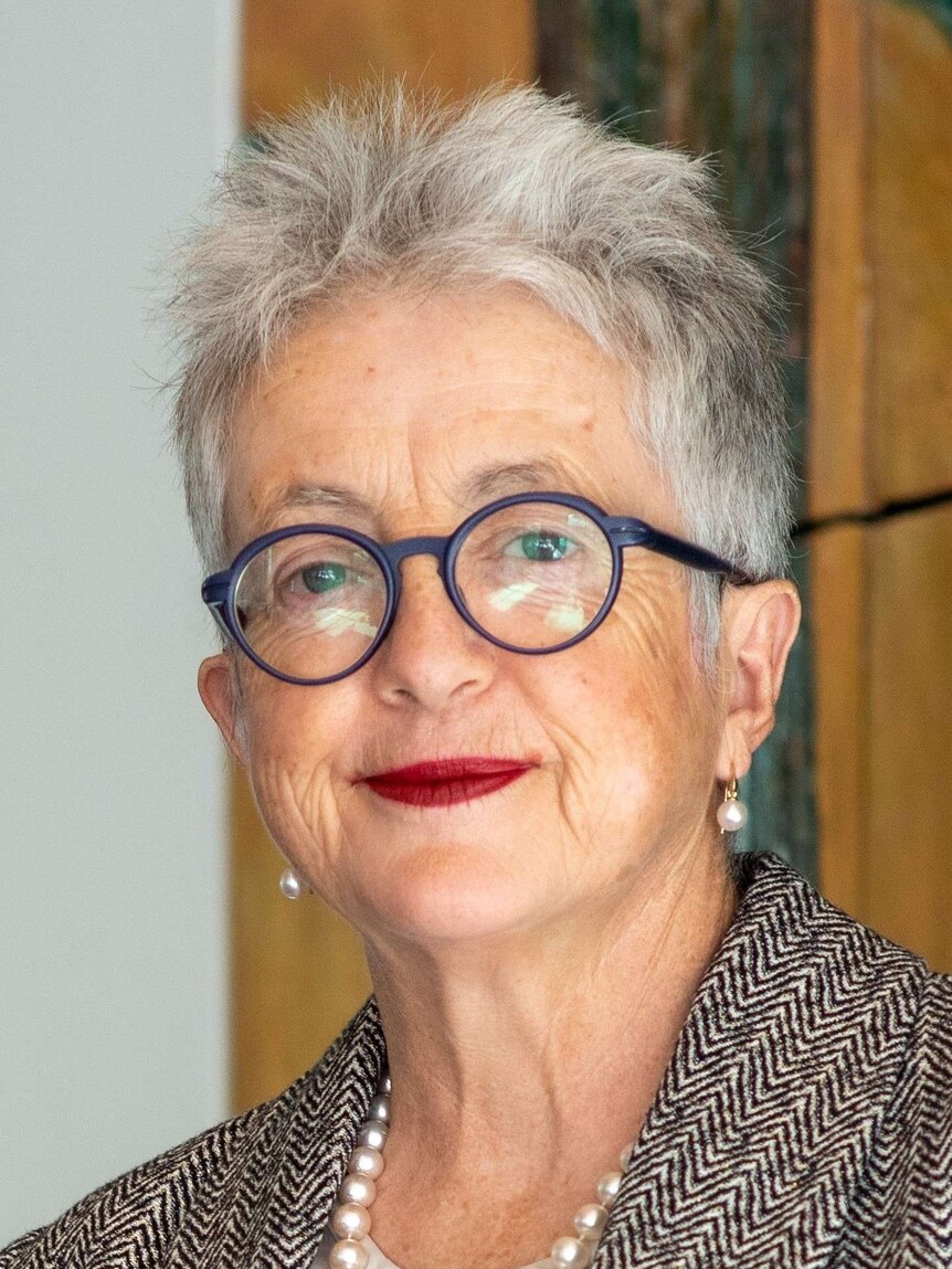 A middle-aged woman with grey hair and spectacles