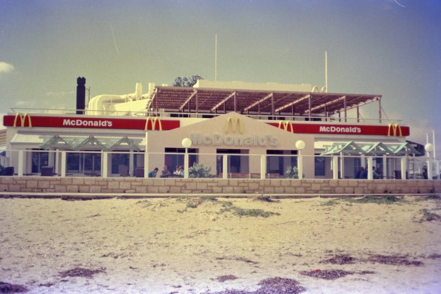 An old photo of a fast food building on a beach