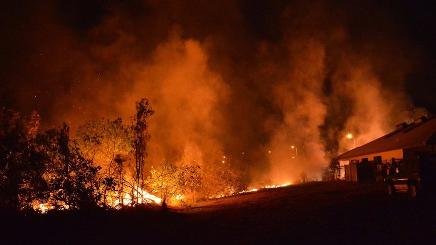 A grass fire moves close to a house in Johnston.