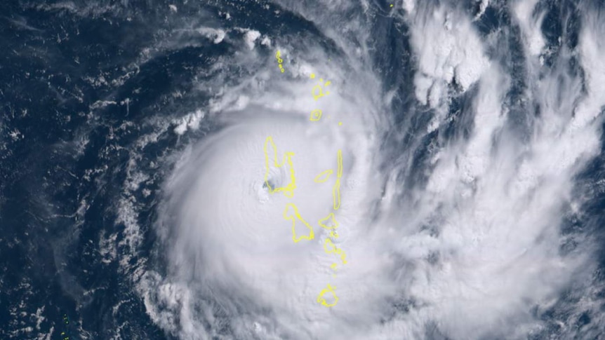 A satellite image shows a cyclone formation over deep blue seas with a yellow outline of Vanuatu's islands superimposed.