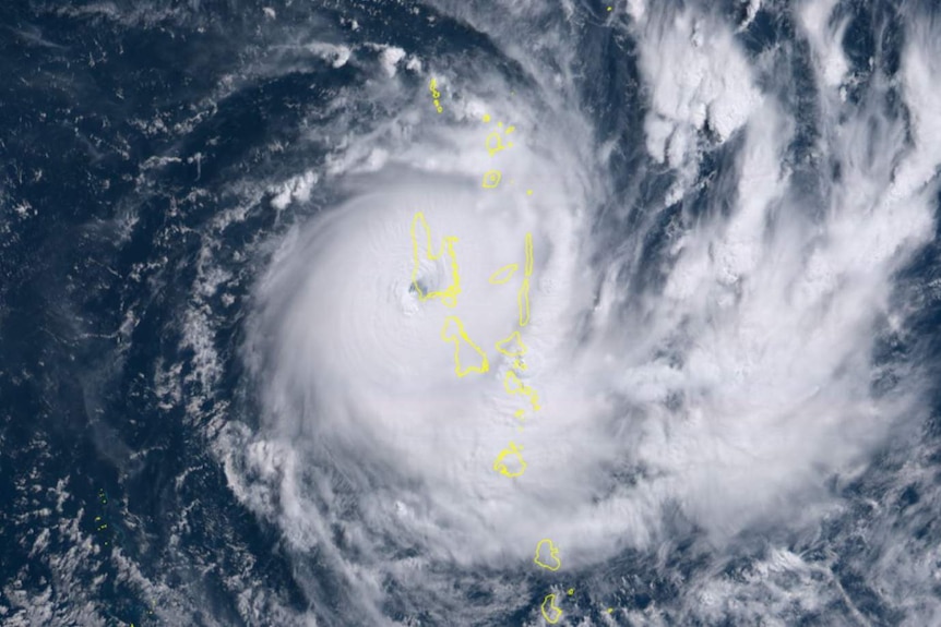 A satellite image shows a cyclone formation over deep blue seas with a yellow outline of Vanuatu's islands superimposed.