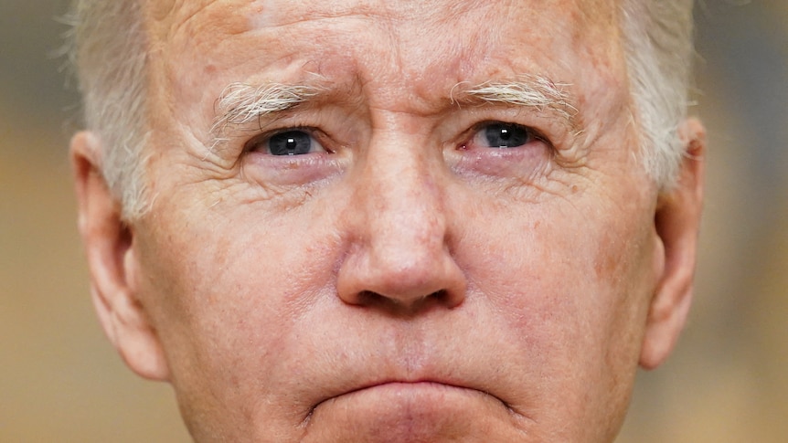 A tight portrait of Joe Biden's face. He's looking solemn 