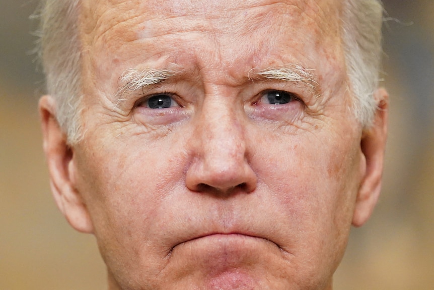A tight portrait of Joe Biden's face. He's looking solemn 