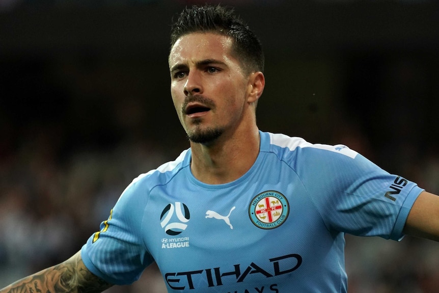 A striker spreads his arms in celebration after scoring a goal in the A-League.