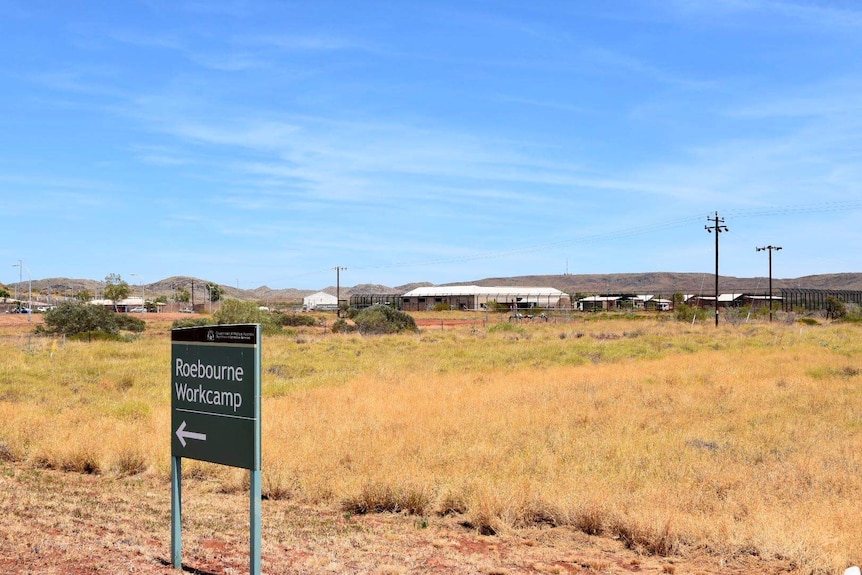 sign with prison in background.