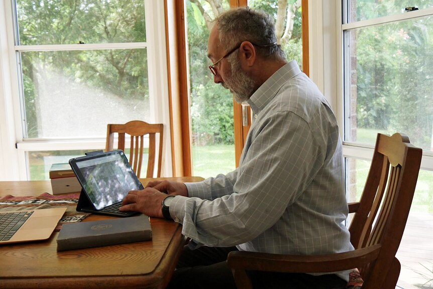 A man looking at an iPad.