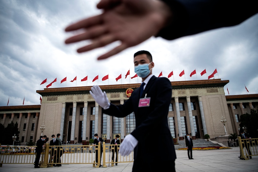 Staff gesture photographers away outside Beijing's NPC.
