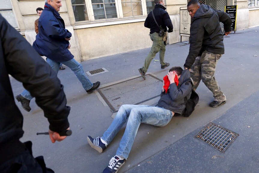 A policemen in civilian clothes arrests a protester.