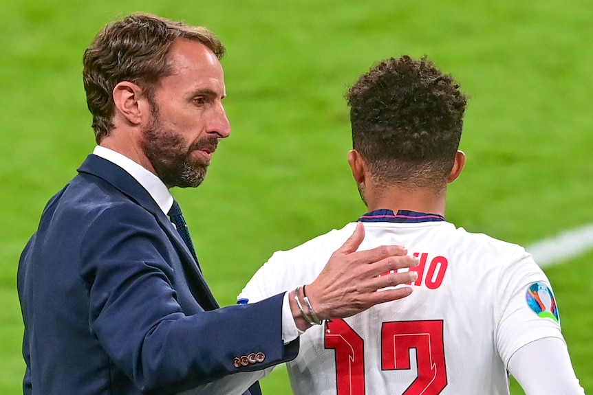 Gareth Southgate puts his hand on the back of Jadon Sancho