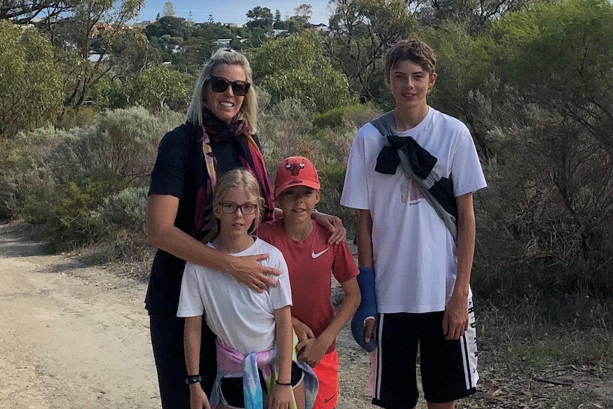 Betsy Merry pictured with her three children in an outdoor setting